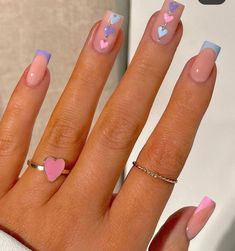 a woman's hand with pink, blue and white manicures on it