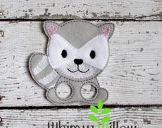 a small gray and white stuffed animal on wood