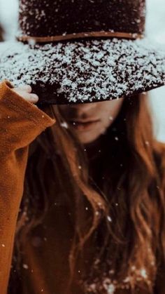 a woman wearing a hat covered in snow