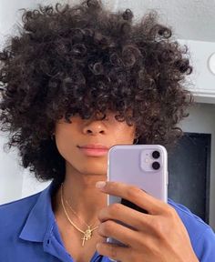 a woman taking a selfie with her cell phone in front of her face and wearing a blue shirt