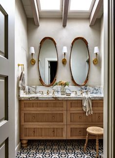 a bathroom with two sinks, mirrors and stools on the side of the room