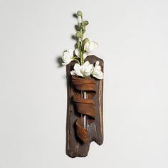 a wooden wall hanging with flowers in it