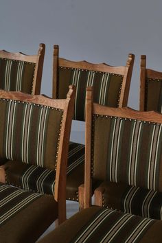 four wooden chairs with striped upholstered seats and back cushions, side by side