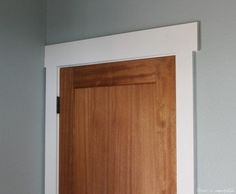 a wooden door with white trim in a room