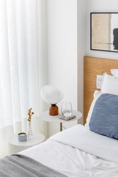 a bed with white sheets and blue pillows