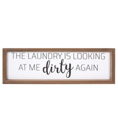 a sign that says the laundry is looking at me dirty again on it's wooden frame