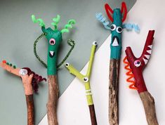 four different colored sticks with faces and hands made to look like people's heads