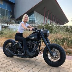 a woman sitting on top of a black motorcycle