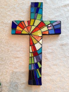 a stained glass cross hanging on the wall