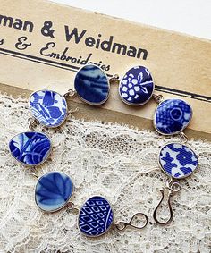 six blue and white glass cabochons are sitting on a lace covered tablecloth