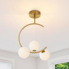 three lights are hanging from the ceiling in a room with white walls and flooring