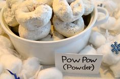 powdered sugar donuts in a white bowl on a table with snowflakes