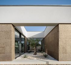 an entrance to a modern house with stone walls and gravel flooring on the outside