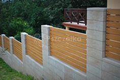 a wooden fence next to a building in the grass