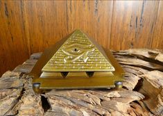 a pyramid shaped object sitting on top of a piece of wood