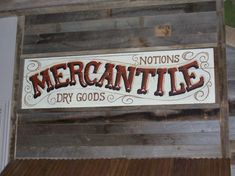 a sign that says mercantile dry goods on the side of a wooden building