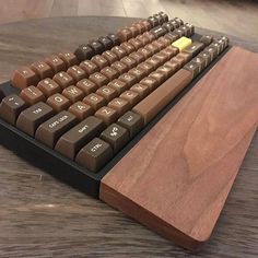 a computer keyboard sitting on top of a wooden table