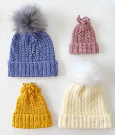 three knitted hats with pom - poms on top and one in the middle