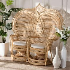 two wicker chairs sitting next to each other in front of a plant and vase