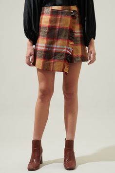 Make your debut in a classic silhouette with this skirt. The Pam Plaid Faux Wrap Mini Skirt has a plaid pattern throughout that shapes a high-waisted fit and an overlapped design that lends a faux-wrap effect. Throw on a matching top along with a pair of boots and you’re all set. - Wrap mini skirt- Faux- Tassel fringe- High waist- Color: Brown multiSize + Fit - Model is 5'8" and wearing size XS- Measurements taken from size S - Waist: 13 1/2"- Length: 16 3/4" Fabric Self:100% Polyester Lining:97 Plaid Wrap Skirt Pattern, Plaid Wrap Skirt, Wrap Skirt Pattern, Upcycle Ideas, Wrap Mini Skirt, Boho Fall, Tassel Fringe, Winter Clothes, Matching Top