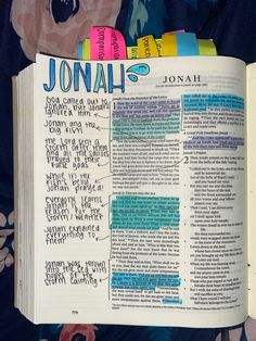 an open bible with the word jonall written on it and colorful papers sticking out of it