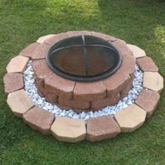 a fire pit sitting on top of a lush green field