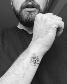 a man with a tattoo on his arm and an all seeing eye tattooed on the wrist