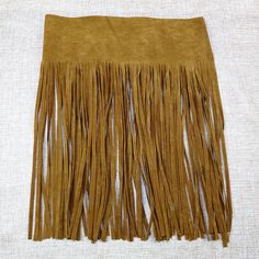 a brown fringe is laying on top of a white cloth