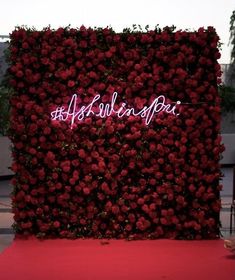 a red carpeted area with a wall covered in flowers