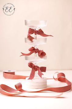 three tiered cake stand with ribbon on top and ribbons in the bottom, along with two rolls of tape