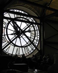 a large clock with roman numerals on it's face in a building