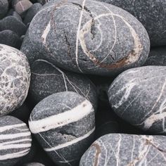 some black and white rocks are stacked up on top of each other with lines painted on them