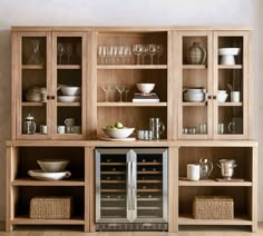 an open cabinet with wine glasses and dishes in it