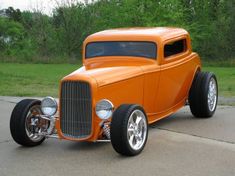 an orange classic car is parked on the street