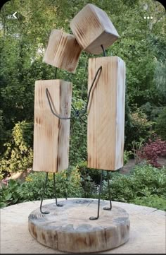 a sculpture made out of wood with two wooden blocks on it's legs and one block in the air