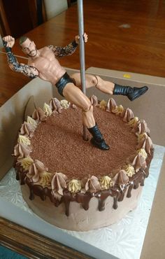 a cake with a wrestler figurine on top and a knife stuck in it