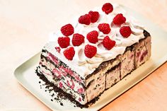 a piece of cake with whipped cream and raspberries on top sitting on a plate