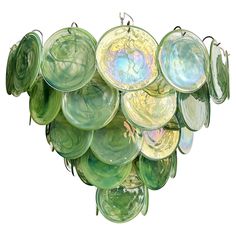 a bunch of green glass plates hanging from hooks