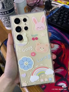 someone holding up a phone case with stickers on it