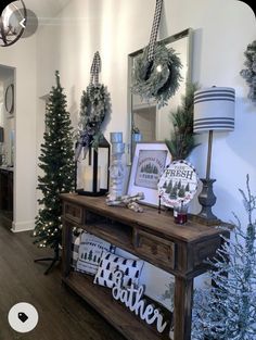 christmas decorations are displayed on a table in the entryway to a home decorated with evergreens, pine cones and wreaths