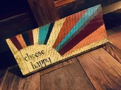 a wooden sign that says choose happy on the side of a wood floor in front of a window