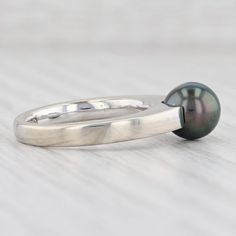 Gem: Cultured Pearl - 7.5 mm, Round Shape, Gray / Black Color - Natural Diamond - 0.02 Total Carats, Round Brilliant Cut, G Color, SI1 Clarity Metal: 18k White Gold Weight: 6.4 Grams Stamps: 750, Movado maker's mark Face Height: 7.6 mm Rise Above Finger: 9.6 mm This ring is a size 5 3/4. Please contact us for sizing options. Each piece is thoroughly examined and refinished as needed by our professional jewelers, graded by our in-house GIA (Gemological Institute of America) Graduate Gemologist, a Mark Face, Pearl Diamond Ring, Pink Tourmaline Ring, Pearl And Diamond Ring, Halo Pendant, Recycled Jewelry, Rise Above, Peridot Ring, Pearl Diamond