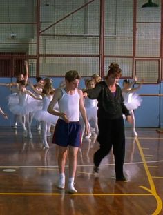 a group of people standing on top of a hard wood floor in a dance studio