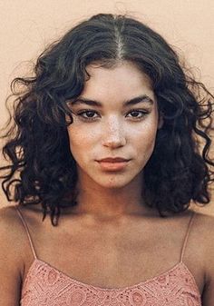 a woman with freckled hair is looking at the camera while wearing a pink top