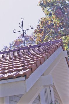 the roof of a house with a weather vane on top