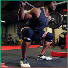 a man is squatting with a barbell in his hands