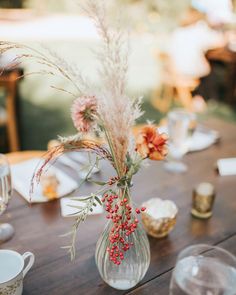 the table is set with plates, cups and vases