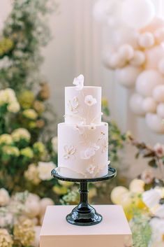 a three tiered white cake sitting on top of a table