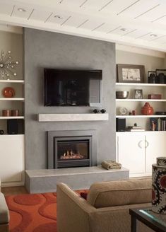 a living room filled with furniture and a flat screen tv mounted on the wall above a fire place