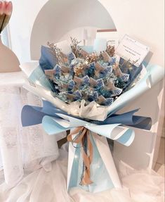 a bouquet of blue and white flowers sitting on top of a table